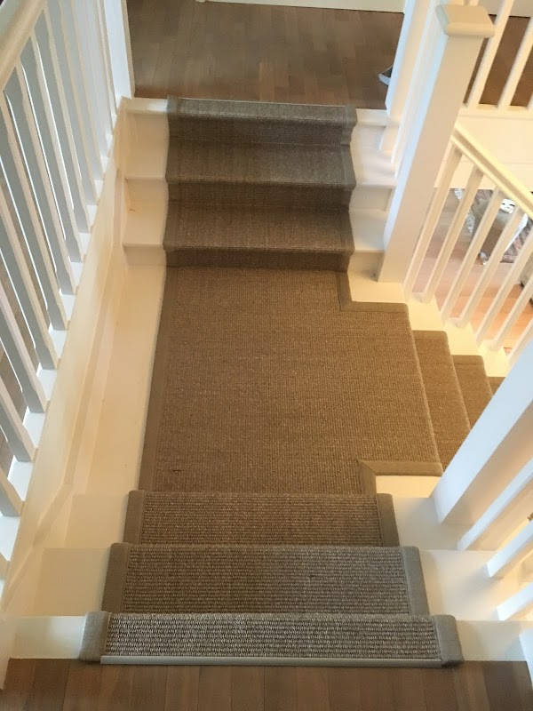Sisal-loper op een witgeschilderde trap met overloop